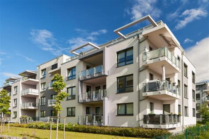 Why are apartments and flats popular in cities?